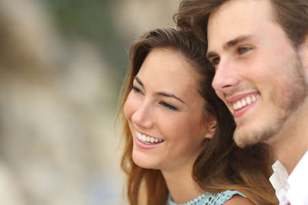 Happy couple in love looking away together with an unfocused backgroundの写真素材