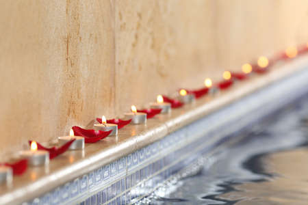 Candles and rose petals in a spa poolside relax and romantic conceptの写真素材