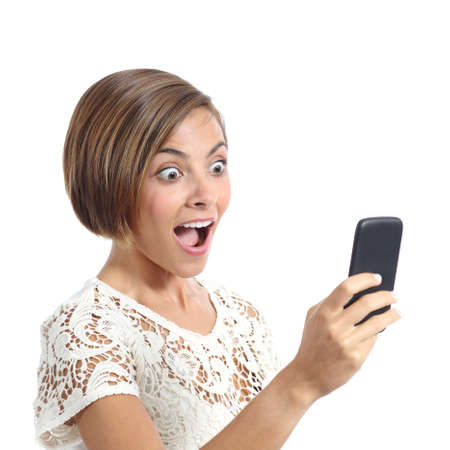 Happy woman surprised looking her smart phone isolated on a white backgroundの写真素材