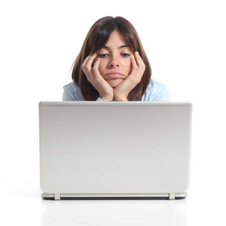 Bored woman watching a laptop isolated on a white backgroundの写真素材