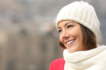 Happy candid girl with white teeth and perfect smile warmly clothed in winterの写真素材