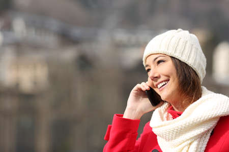 Girl talking on the mobile phone warmly clothed in winterの写真素材