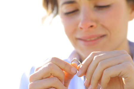 Sad girlfriend crying while is looking her engagement ring