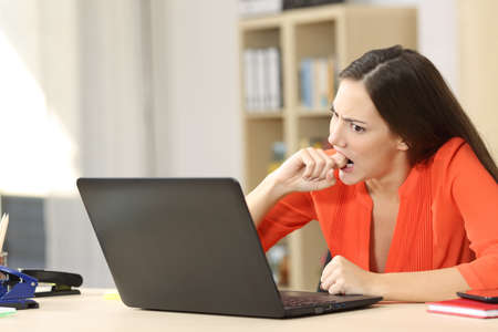 Angry entrepreneur furious with a laptop working in an office or homeの写真素材
