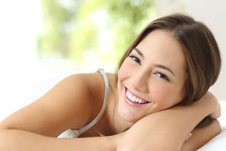 Beauty girl with white teeth and perfect smile looking at camera at homeの写真素材