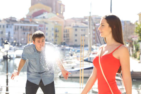 Man amazed looking at a sexy girl walking in the street of a vacational destination in a port urbanization with the sea in the backgroundの写真素材