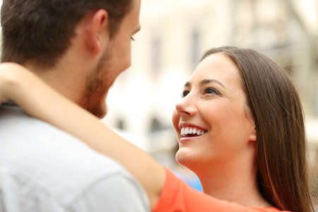 Happy couple in the street looking each other falling in loveの写真素材
