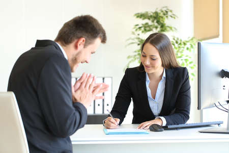 Businesspeople wearing suit signing contract after a successful deal at office