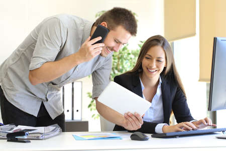 Business team coworking with multiple devices and a desktop computer at officeの写真素材