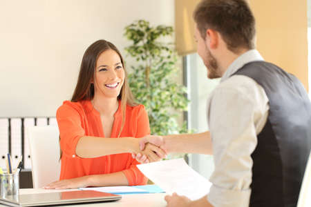 Happy employee and boss handshaking after a successful job interview at office