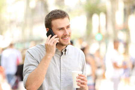 Man walking and talking on the mobile phone in the streetの写真素材