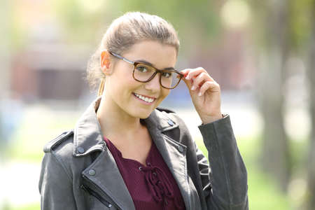 Fashion girl wearing eyeglasses and looking at you in the streetの写真素材
