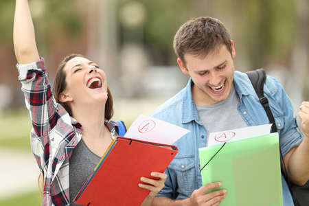 Two excited students with approved exams in the streetの写真素材