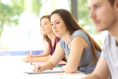 Distracted student looking away during a class in a classroomの写真素材