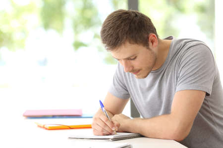 Single student studying taking notes alone in a classroomの写真素材