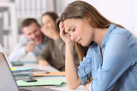 Side view portrait of a bullying victim being criticized at office