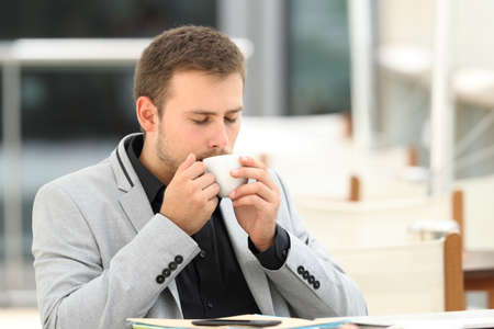 Executive drinking enjoying coffee break sitting in a barの写真素材