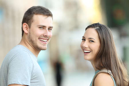 Portrait of a happy couple of teenagers looking at camera on the streetの写真素材