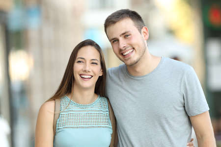 Front view portrait of a happy couple walking together on the streetの写真素材