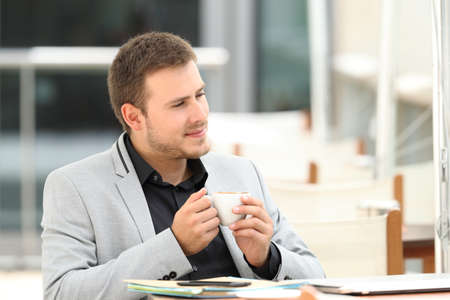 Portrait of a serious executive thinking sitting in a coffee shopの写真素材