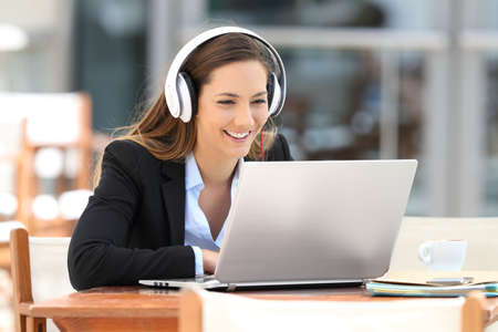 Portrait of a young executive girl watching video lecture on line sitting in a coffee shop