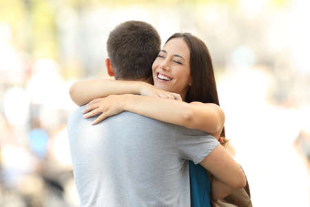 Happy girlfriend hugging her partner after encounter on the street