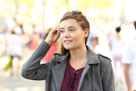 Portrait of a pretty teen looking away walking on the streetの写真素材