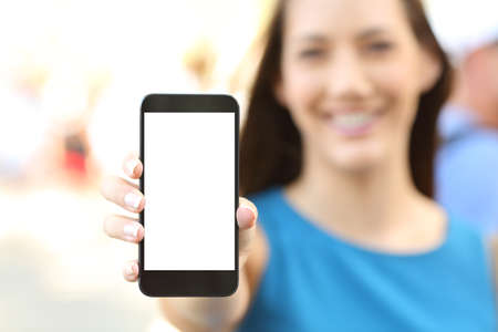 Close up of a female showing a blank vertical phone screen on the streetの写真素材