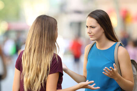 Two angry friends having a serious conversation outdoors on the streetの写真素材