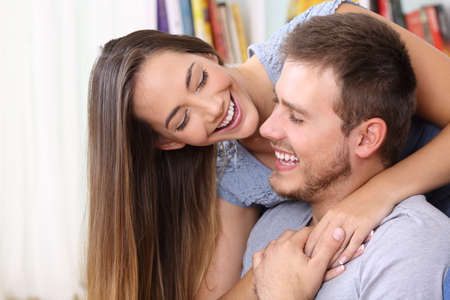 Happy couple in love flirting looking each other at homeの写真素材