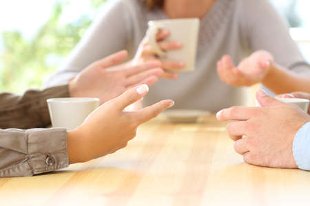 Close up of three friends hands talking sitting in a bar or houseの写真素材