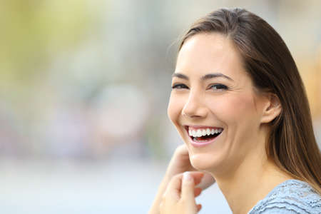 Portrait of a happy woman smiling looking at camera on the streetの写真素材