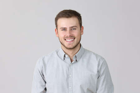 Front portrait of a happy man isolated on a grey background