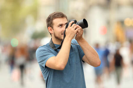 Happy photographer taking photos on the street with a dslr cameraの写真素材