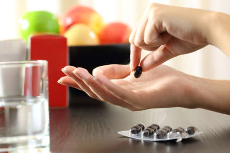 Close up of a woman hand catching a vitamin complex pillの写真素材