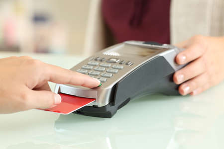 Close up of a customer typing pin in a credit card reader on a counter in a store