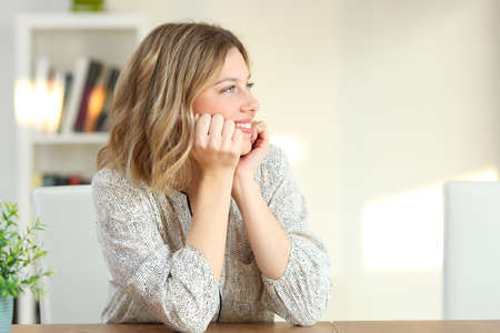 Portrait of a pensive housewife looking at side on a table at home