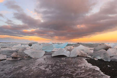 Icelandic glacier Jokulsarlon with icebergs on the beach at sunset