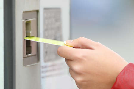 Close up of a woman hand paying using a credit card in a payment machine outdoorsの写真素材