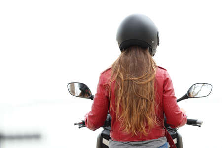 Back view of a motorbiker sitting on a motorcycle on white backgroundの写真素材