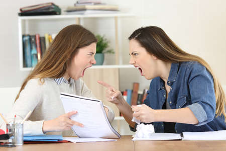 Two angry students arguing doing homework at homeの写真素材