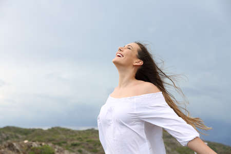 Positive woman breathing fresh air enjoying the wind