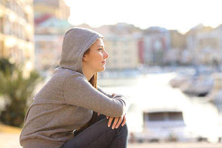 Side view portrait of a relaxed teen looking away in a coast town streetの写真素材