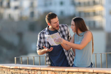 Angry couple arguing about travel destination on vacation in a townの写真素材