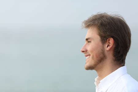 Side view portrait of a happy man looking away on the beachの写真素材