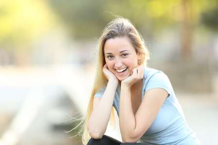 Portrait of a happy teenage girl posing looking at camera in a parkの写真素材