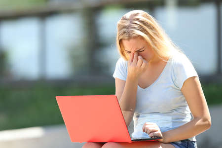 Student with eyesight problems suffering eyestrain outdoors in an university campusの写真素材