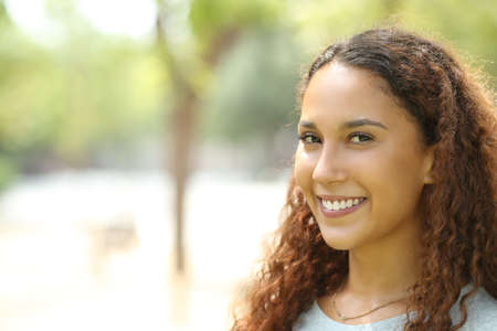 Beauty mixed race woman posing looking at camera with perfect smile in a parkの写真素材