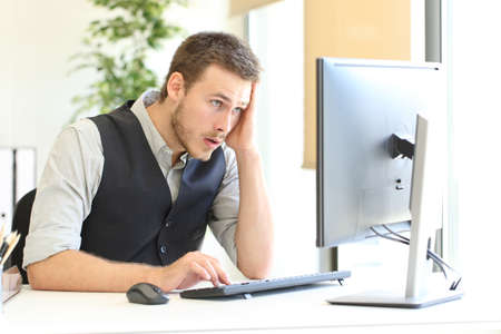 Worried executive complaining after discover mistake on computer at officeの写真素材