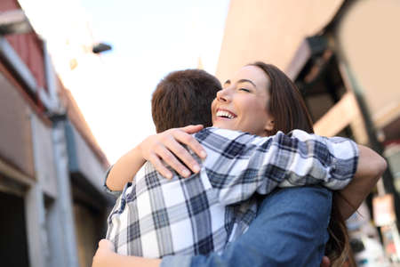 Joyful couple hugging in the street of an old town after meetingの写真素材
